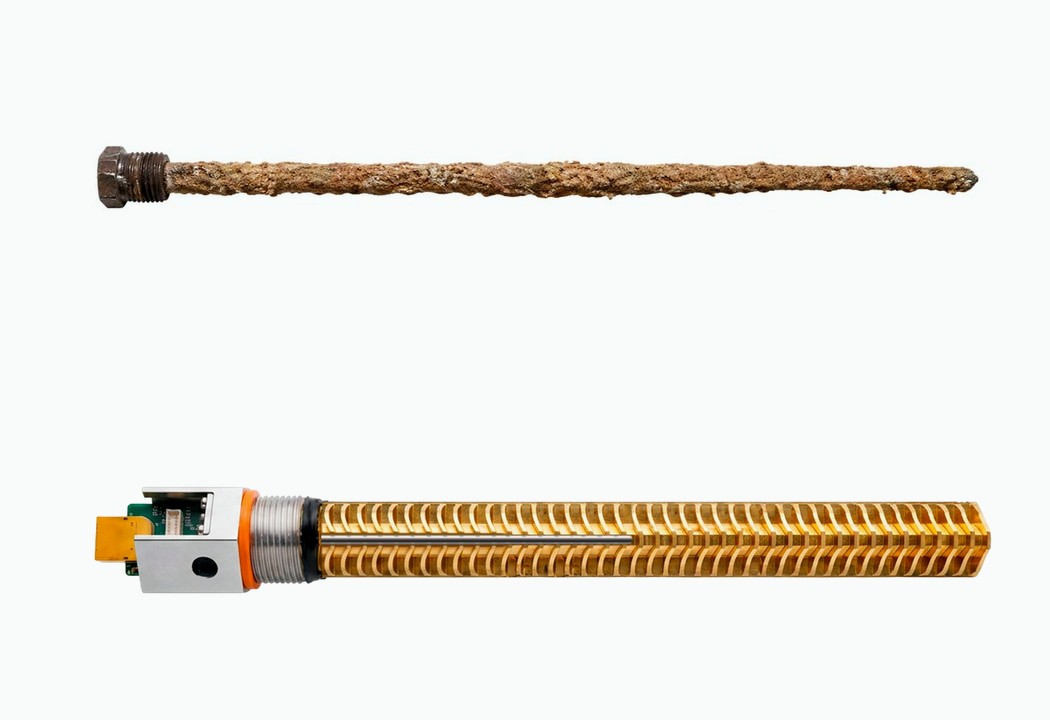 A corroded sacrificial anode rod next to Bitwater with its powered titanium anode