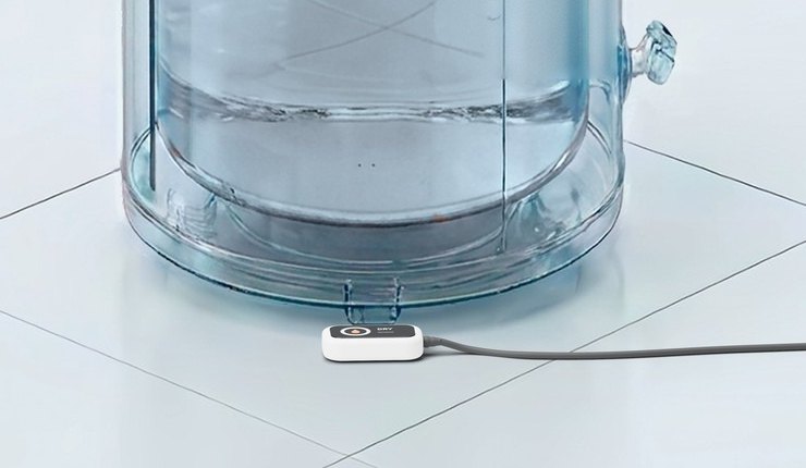 The base of a water heater tank with the Bitwater leak sensor on the floor