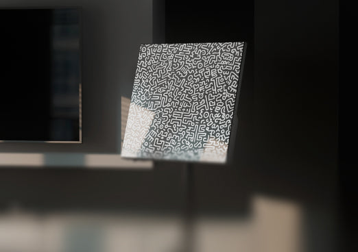 Heatbit Canvas with geometric pattern standing next to a wall with a TV-set