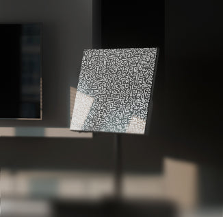 Heatbit Canvas with geometric pattern standing next to a wall with a TV-set