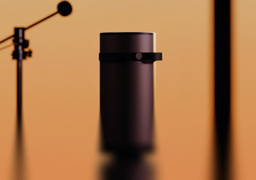 Heatbit Maxi device with a microphone and studio lighting on a brown background