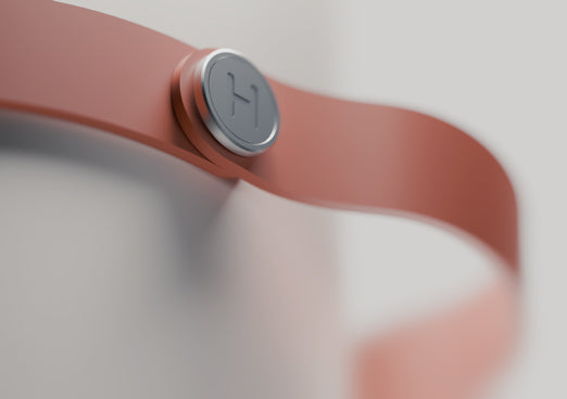 Close-up of Heatbit Trio with a silver button on a brown band